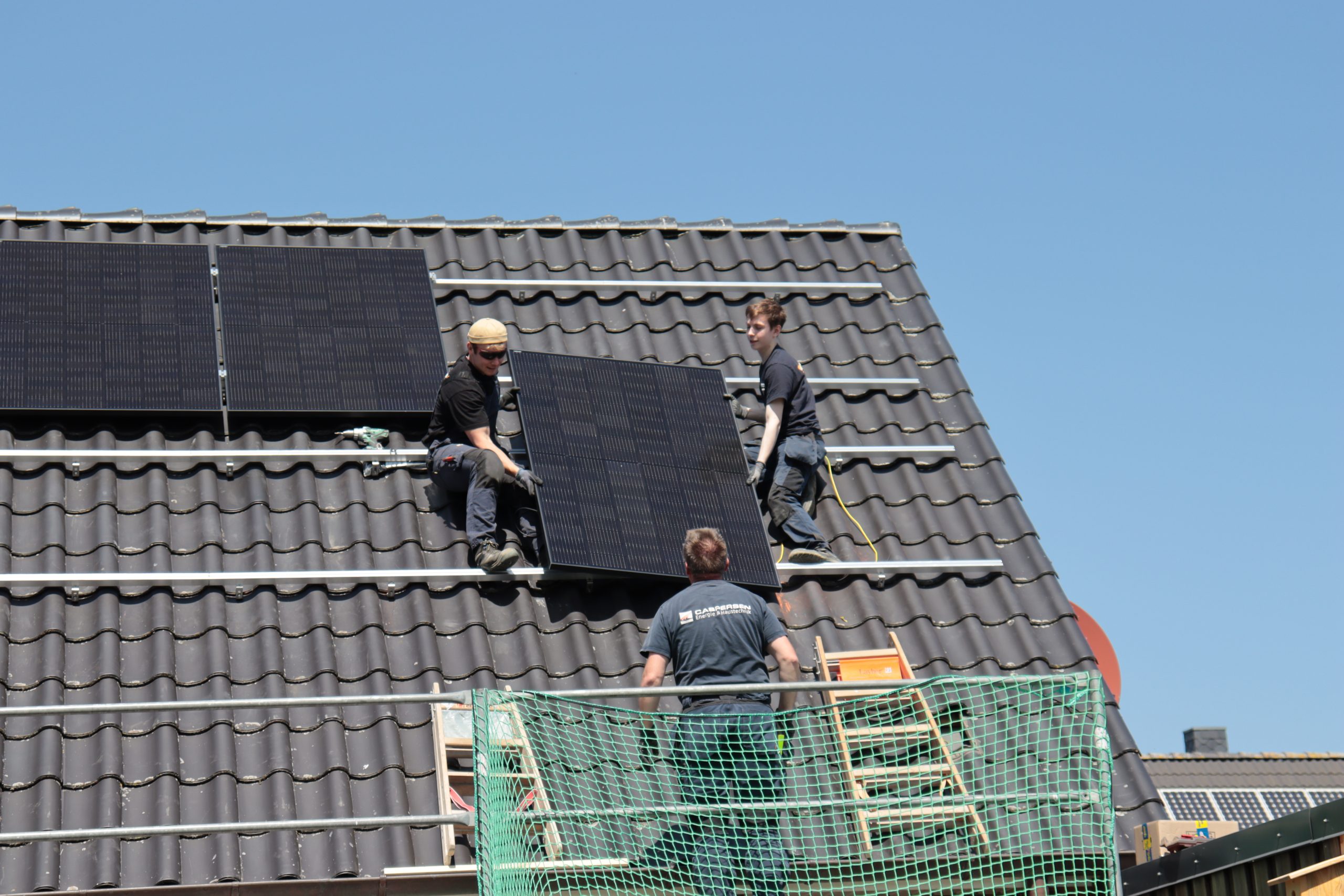 Mitarbeiter bei der Montage von Solarmodulen auf dem Dach